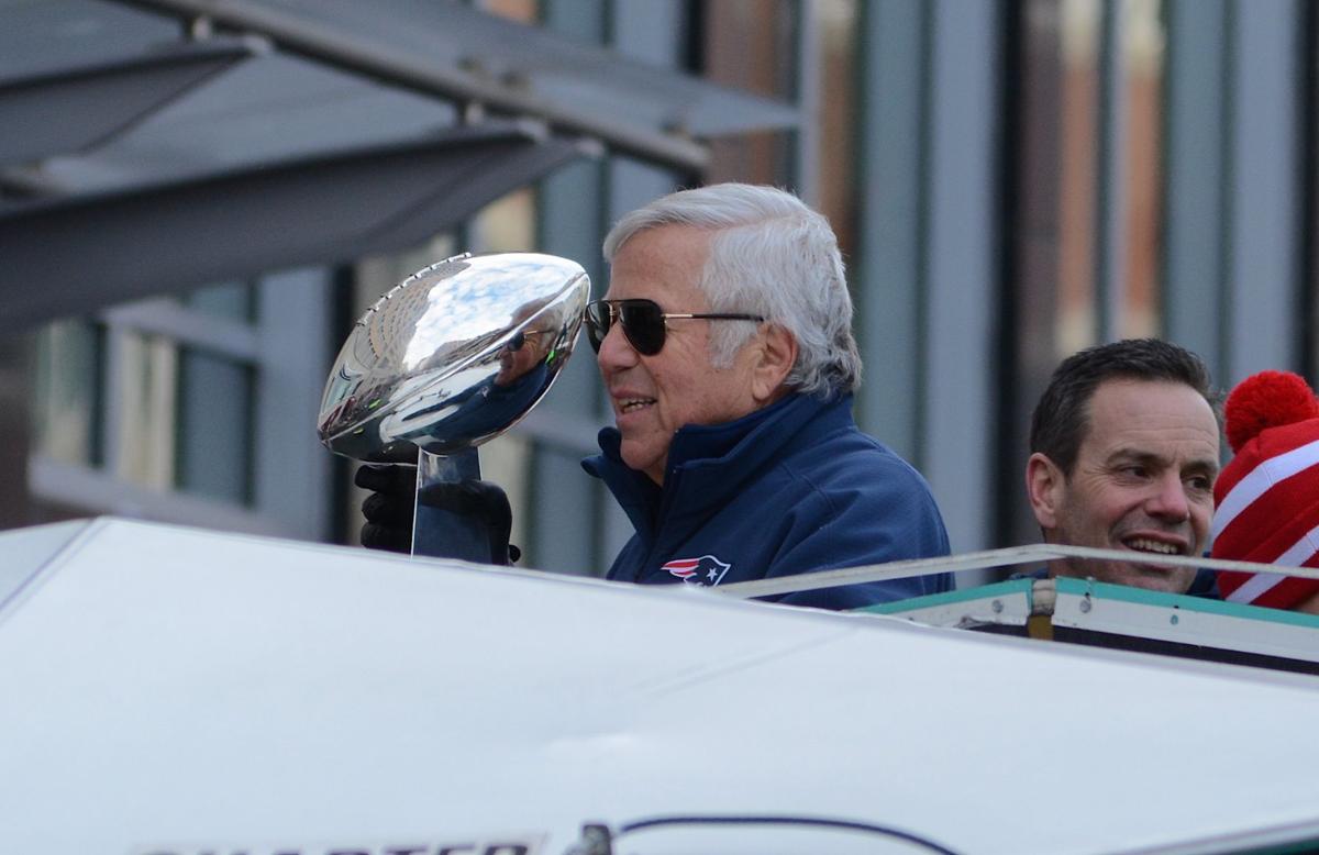 New England Patriots owner Robert Kraft holds up the Vince Lombardi Trophy to the crowd as he rides down Boylston Street during the team's celebratory parade.