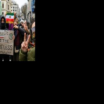 Protesters hold a placard reading 'Voice for the voiceless' and the flag of Iran from before the 1979 revolution during a demonstration outside the Iranian Consulate in Istanbul