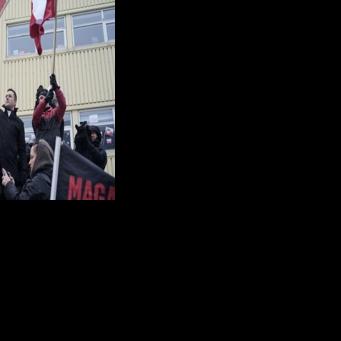 Greenland's prime minister Jens-Frederik Nielsen (L) holds a Greenlandic flag at a demonstration against US President Donald Trump's wish to take over the territory
