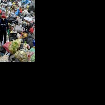 A woman picks up plastic waste at a landfill on the outskirts of Hanoi