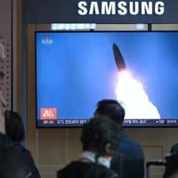People at a train station in Seoul watch footage of a North Korean missile test