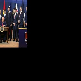 US President Donald Trump, surrounded by several Latin American leaders, signs a proclamation at the 'Shield of the Americas' summit in Doral, Florida