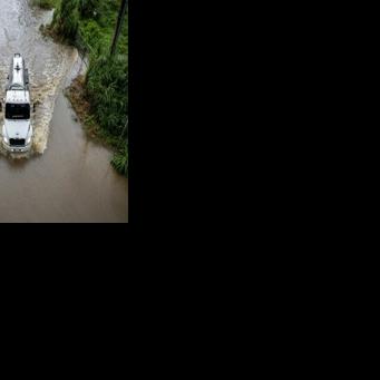 A truck drives through a flooded road as Category 3 Hurricane Erin leaves the region in Naguabo, Puerto Rico