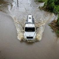 A truck drives through a flooded road as Category 3 Hurricane Erin leaves the region in Naguabo, Puerto Rico