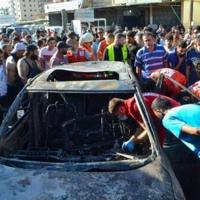 Paramedics inspect a burnt vehicle, which was targeted in an Israeli airstrike, in the Ayrouniyeh area near Lebanon's northern port city of Tripoli on July 8, 2025