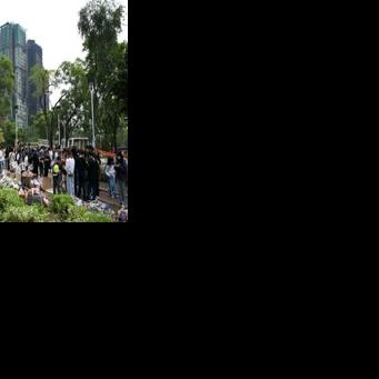 People pay their respects for the victims of a deadly fire at the Wang Fuk Court residential estate in Tai Po district of Hong Kong on December 7, 2025.