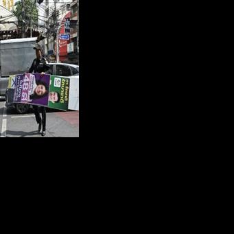 Bangkok Metropolitan Administration workers take down election posters a day after the general election in which the Pheu Thai was projected to come third