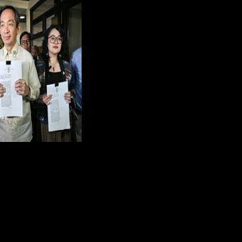 Lawmakers Sara Elago, Antonio Tinio and Louise Co show the impeachment complaint against Philippine President Ferdinand Marcos at the House of Representatives on Thursday