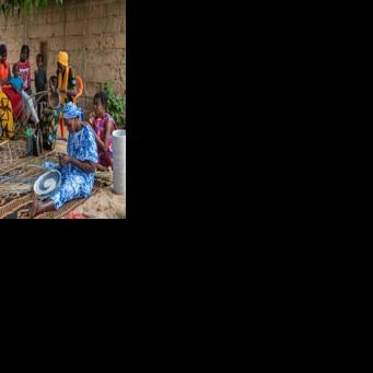 Women weave baskets using coloured recycled plastic strands under a mango tree in Khady Sene's courtyard in the village of Mborine, Senegal
