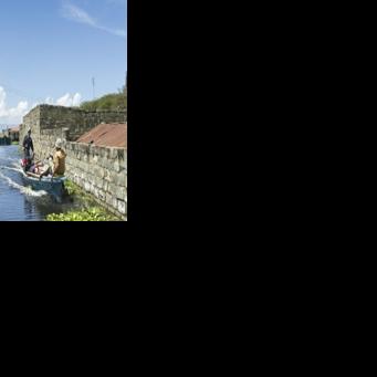 Un bateau transporte un homme contraint par la montée des eaux d'évacuer avec ses biens son quartier des bords du lac Naivasha, dans le centre du Kenya, le 17 novembre 2025