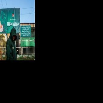 A man walks past a campaign billboard for Sunday polls in Myanmar the military is touting as a return to democracy and international observers are decrying as a sham