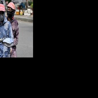 Motorcyclists cover up to avoid the scorching sun in Hanoi