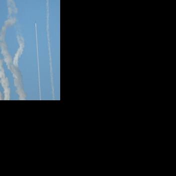 A rocket and plumes of smoke are seen in the sky above Pingtan as the Chinese People's Liberation Army conduct military drills