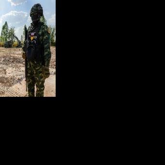 Soldiers stand guard in front of an excavator filling a truck with debris on February 5, 2026 during a military organised tour near Ban Nong Chan, an area now controlled by Thai forces