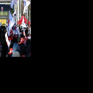 Supporters of South Korea's ousted president Yoon Suk Yeol watch a video of him declaring martial law during a rally marking the first anniversary of the botched takeover.