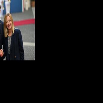 Italy’s Prime Minister Giorgia Meloni (R) shakes hands with France's President Emmanuel Macron in Rome