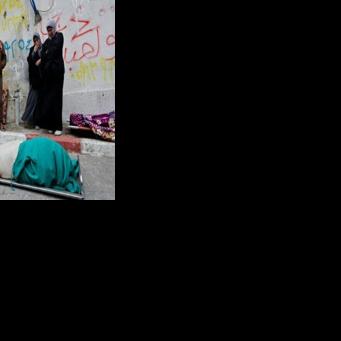 Palestinians mourn over a body