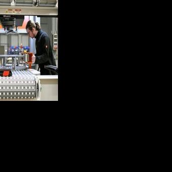 Employees work at a machine at the German firm 4JET