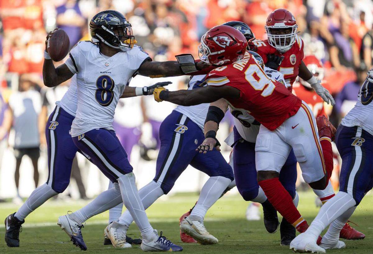 Baltimore Ravens quarterback Lamar Jackson is slowed by Kansas City Chiefs defensive end Charles Omenihu in the first half at GEHA Field at Arrowhead Stadium on Sunday, Sept. 28, 2025, in Kansas City, Missouri.