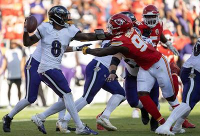 Baltimore Ravens quarterback Lamar Jackson is slowed by Kansas City Chiefs defensive end Charles Omenihu in the first half at GEHA Field at Arrowhead Stadium on Sunday, Sept. 28, 2025, in Kansas City, Missouri.