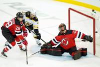 The puck sails wide of New Jersey Devils goaltender Scott Wedgewood (41)  with Boston Bruins left wing Nick Ritchie (21) threatening as New Jersey  Devils defenseman Damon Severson (28) keeps Ritchie at