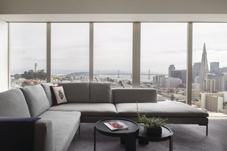 Living room with a view: Much of the furniture, such as the classic sectional by B&B Italia and Cassina nesting tables in a lacquered black finish, was previously owned and intentionally curated to complement the stunning city views. | Photo courtesy of...
