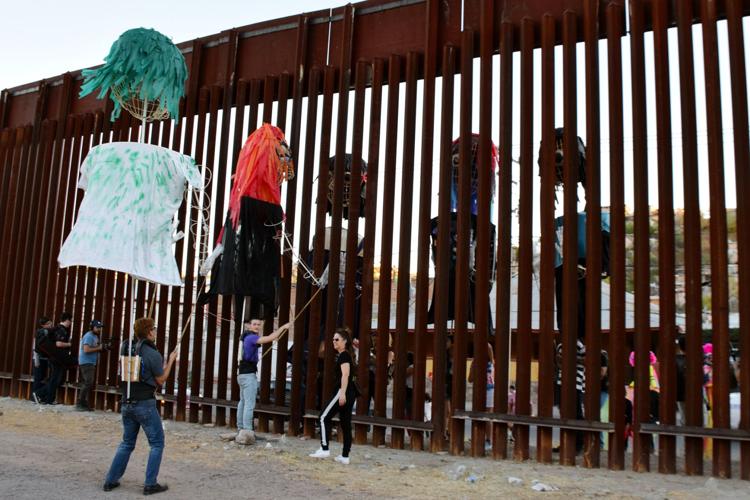 Giant puppets frolic at the border fence, Local News Stories