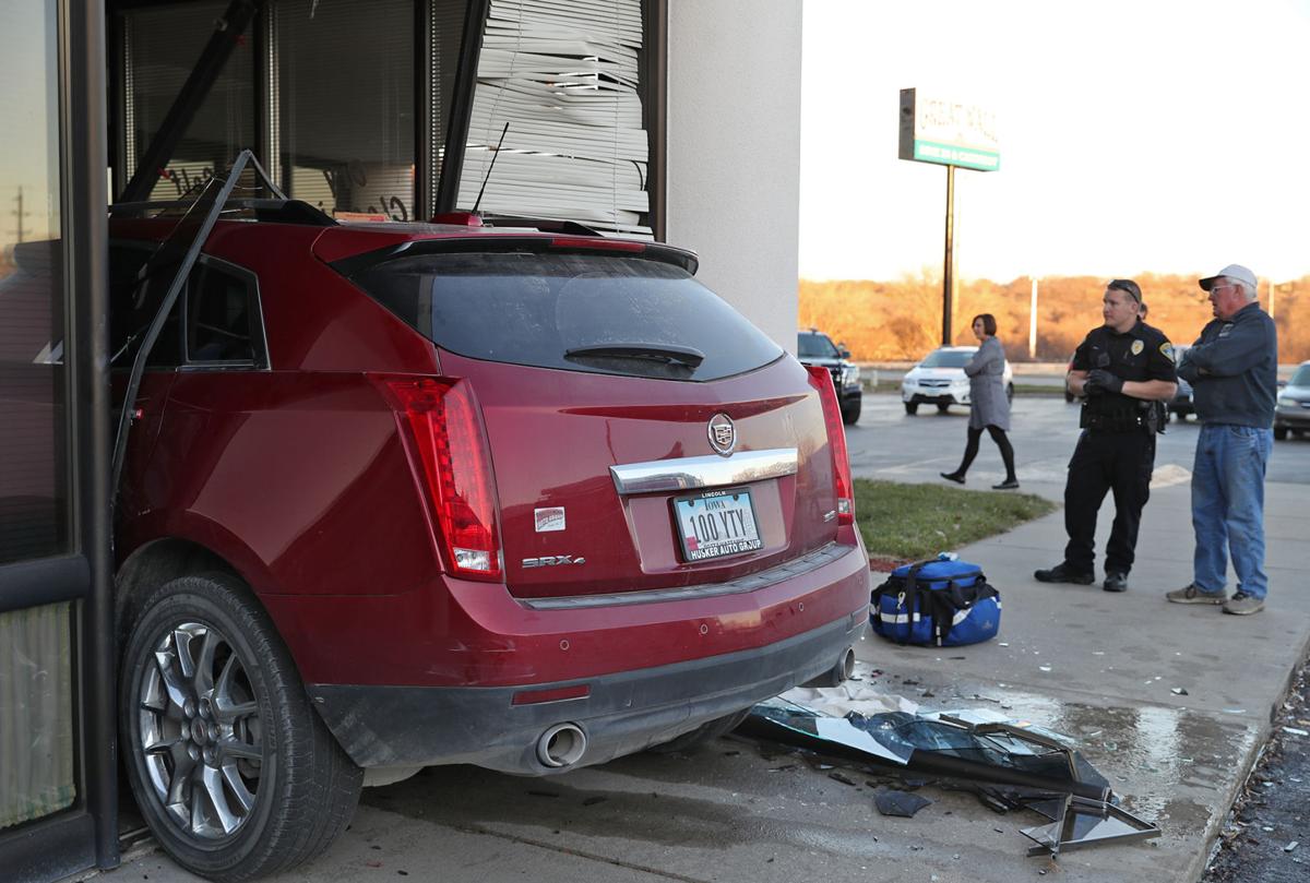 Cadillac crashes into laundry business, as manager worked a window away