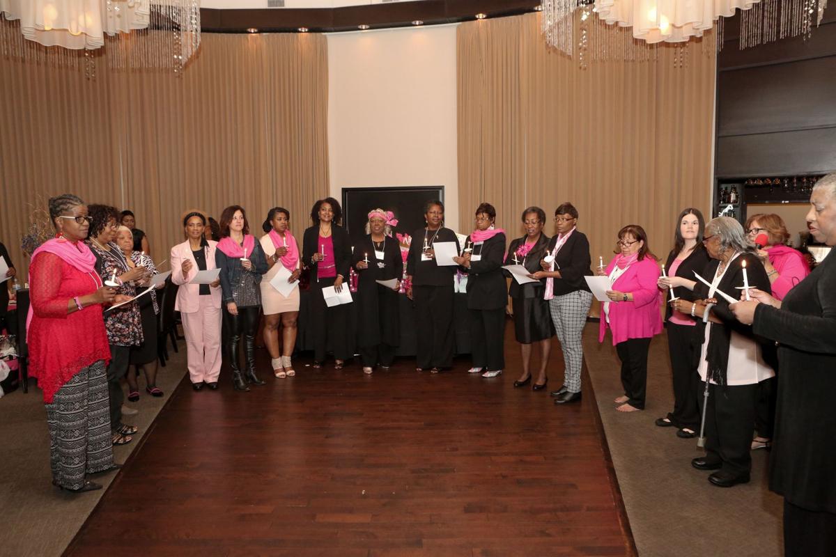 Guests at the Jubilation event read the poem "a Wing and a Prayer" by Michelle Butler as they hold lighted candles. The event was  to honor breast cancer survivors and those who have lost the battle.