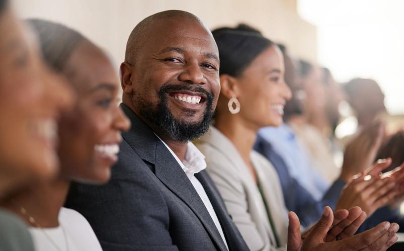 Cropped portrait of a handsome mature businessman applauding while sitting with his colleagues in the boardroom during a presentation