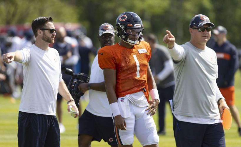 Quarterback Justin Fields practices with quarterbacks coach Andrew Janocko, left, and offensive coordinator Luke Getsy during training camp Tuesdayat Halas Hall.