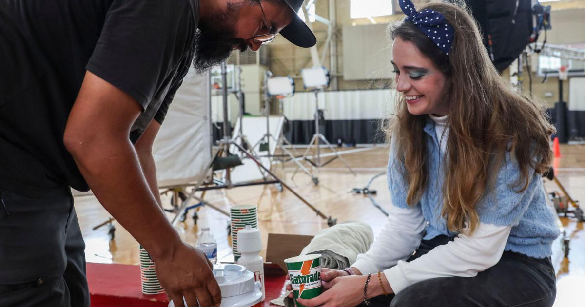 Prop master Cameron Martinez Jr. and Co-Producer Mia Siffin, of Bloomington, prepare for a scene Tuesday, Aug. 11, 2026, during filming at Bill Garrett Fieldhouse in Bloomington, Ind.