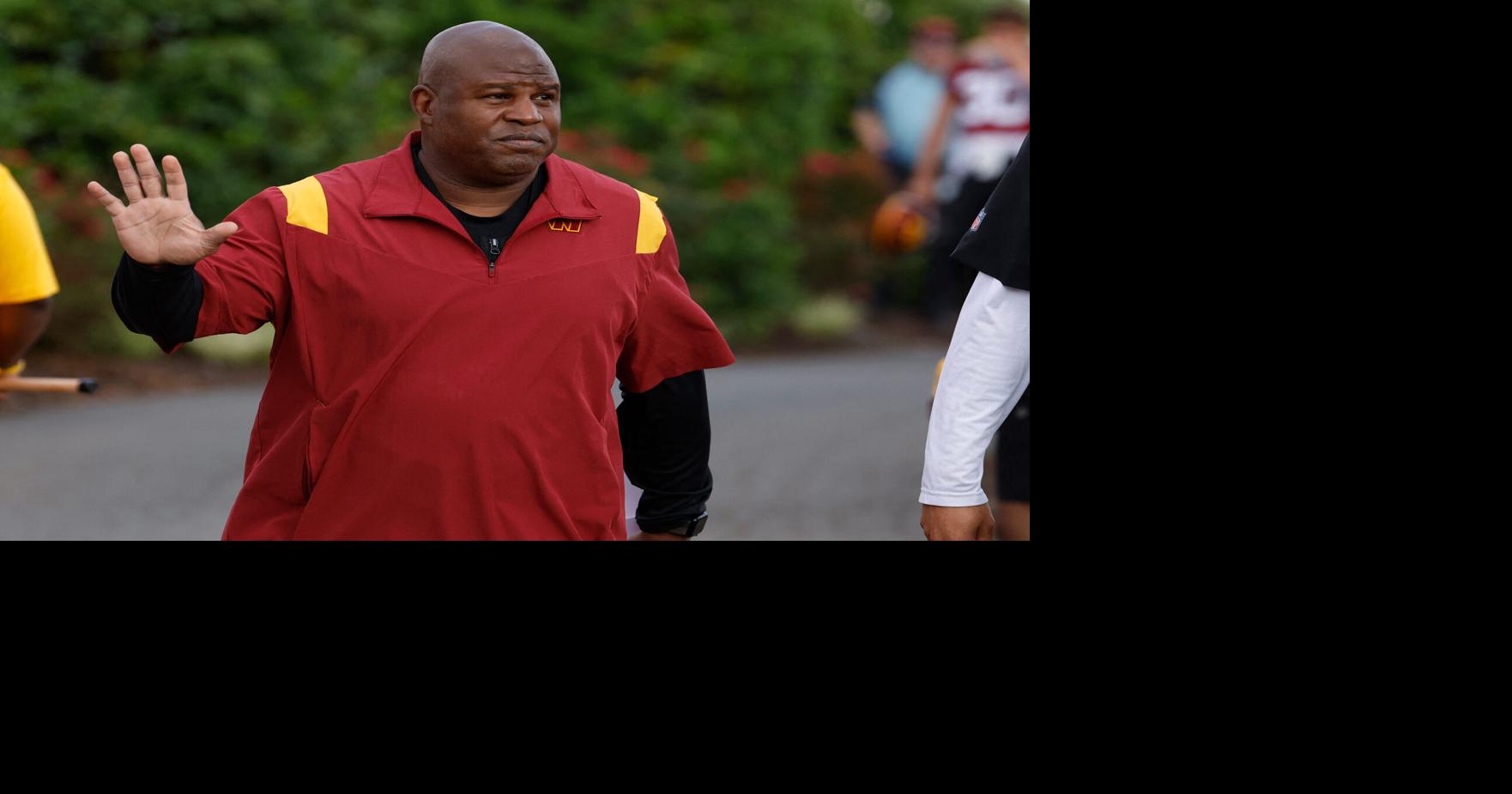 Eric Bieniemy, then the Washington Commanders offensive coordinator, waves to fans while walking to the fields prior to Day 2 of the Commanders 2023 training camp at OrthoVirginia Training Center in Ashburn, Virginia.