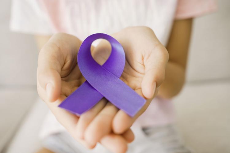 Hands holding purple ribbon, Alzheimer's disease, Pancreatic cancer, Epilepsy awareness, world cancer day, cancer survivor day, concept