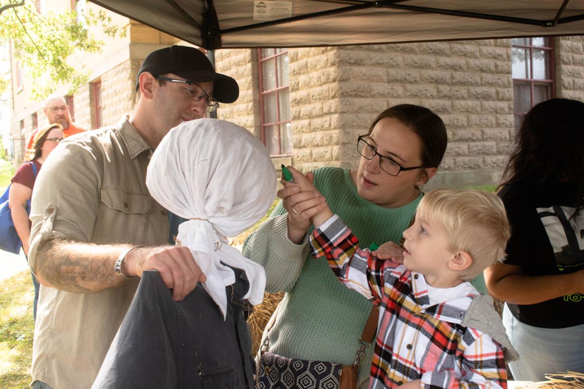 Jeremy and Mandy Donohue help Orion Donohue construct a scarecrow.