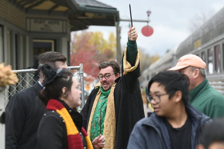UDHR president John Perks, dressed in wizard's robes, raises his wand in the air