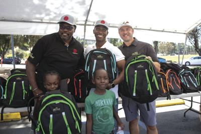 Lending a Hand: Rose Bowl site of backpack giveaway Feature Stories