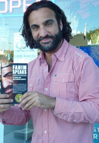 Fahim holding his book. Photo by Tom Blake