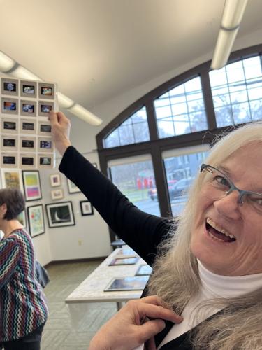 Judith Ellers holds up a sheet of slides of art she created in the 1980s