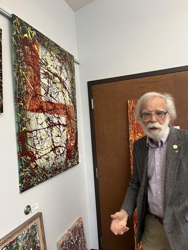 Art Brod stands with his painting "The Intrusion of Autumn."