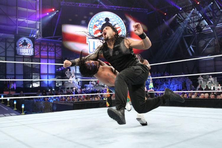 Roman Reigns WWE Autographed 16 x 20 Raising Titles Photograph