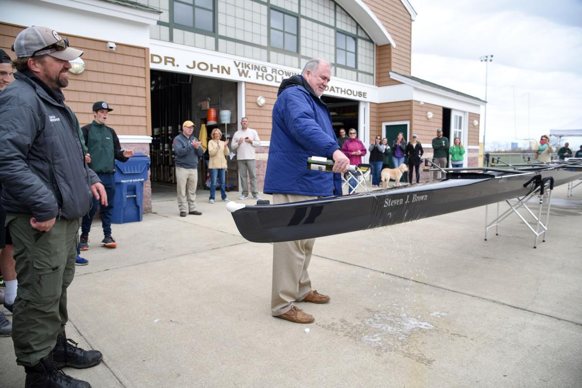 Former Mainland Crew Coach Steven J. Brown, from Atlantic City, christens a new crew boat dedicated in his honor during the First Annual Back Bay Challenge held at the Dr. John W. Holland Boathouse in Ventnor. Dave Griffin / for the Press