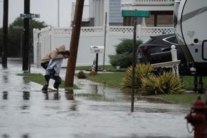 Children walk along a flooded Bay Avenue in Union Beach following a coastal storm that impacted the Jersey Shore on October 13, 2025