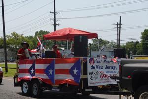 Parade scene from the 60th Annual Vineland Puerto Rican Festival with participants and crowds on Landis Avenue