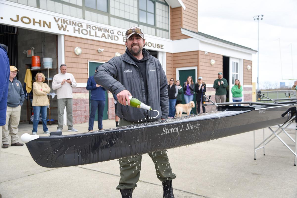 Mainland Crew Eric Somershoe, from Ventnor, christens a new crew boat dedicated to former Mainland Crew Coach Steven J. Brown during the First Annual Back Bay Challenge held at the Dr. John W. Holland Boathouse in Ventnor. Dave Griffin / for the Press