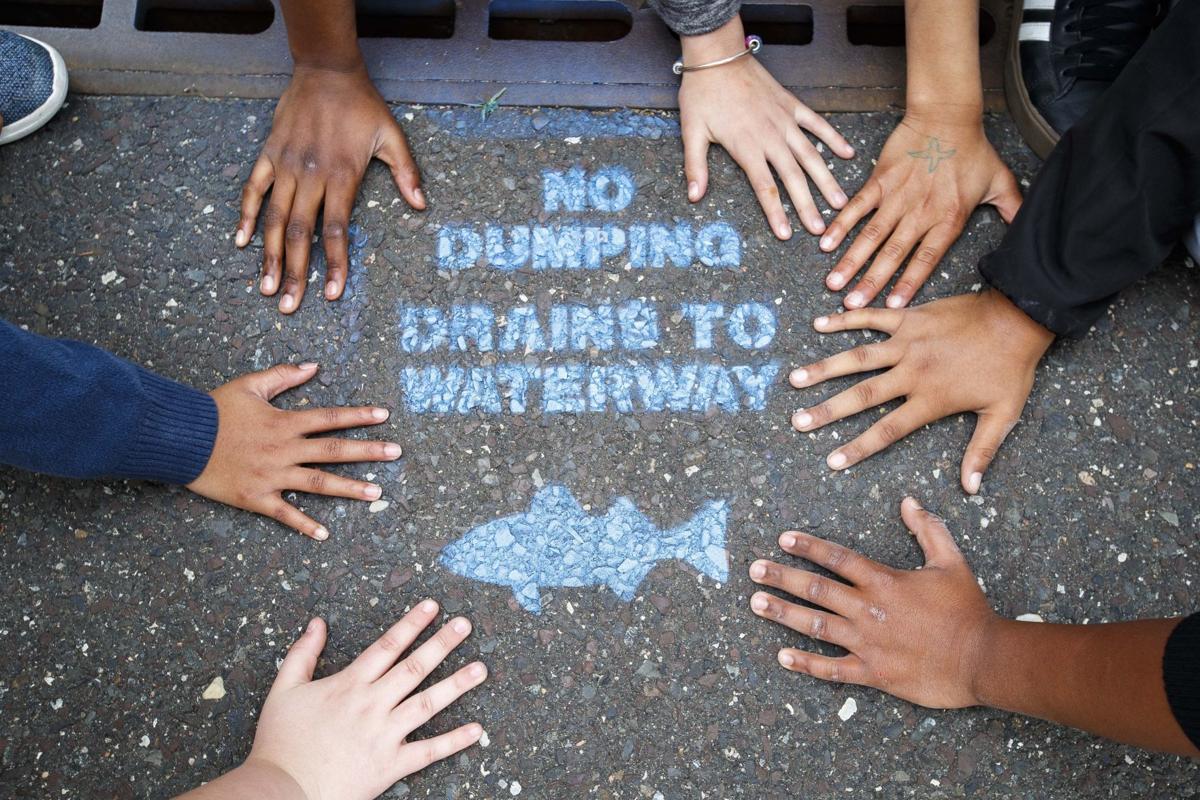Students tackling storm drain pollution with spraypaint campaign