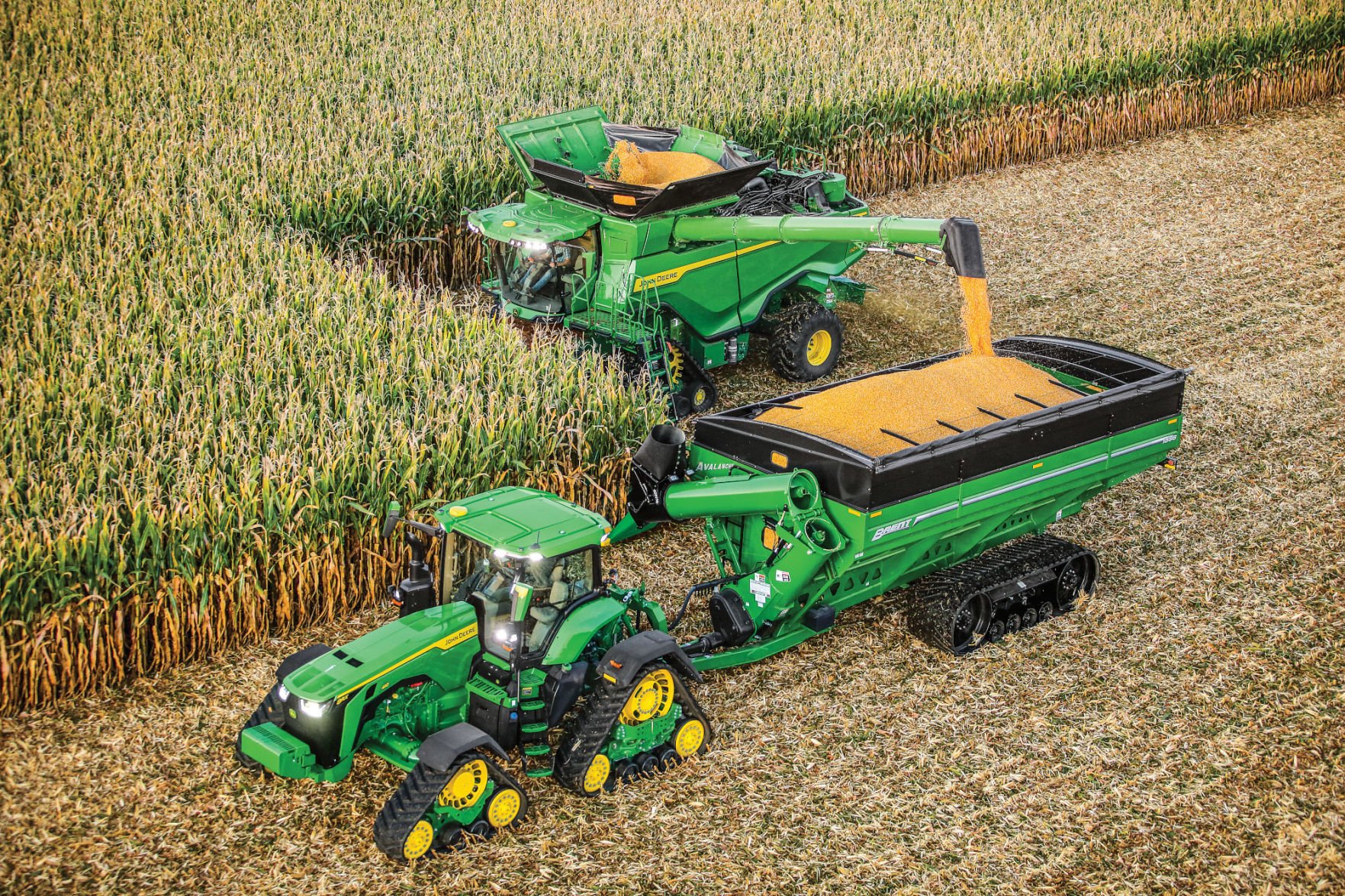 Image of John Deere 300 garden tractor driving through a field of corn