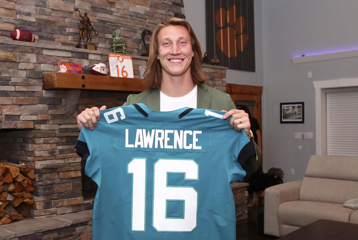 In a handout photo provided by the National Football League, quarterback Trevor Lawrence poses after being selected with the first overall pick by the Jacksonville Jaguars in the NFL Draft on Thursday, April 29, 2021 in Seneca, S.C..