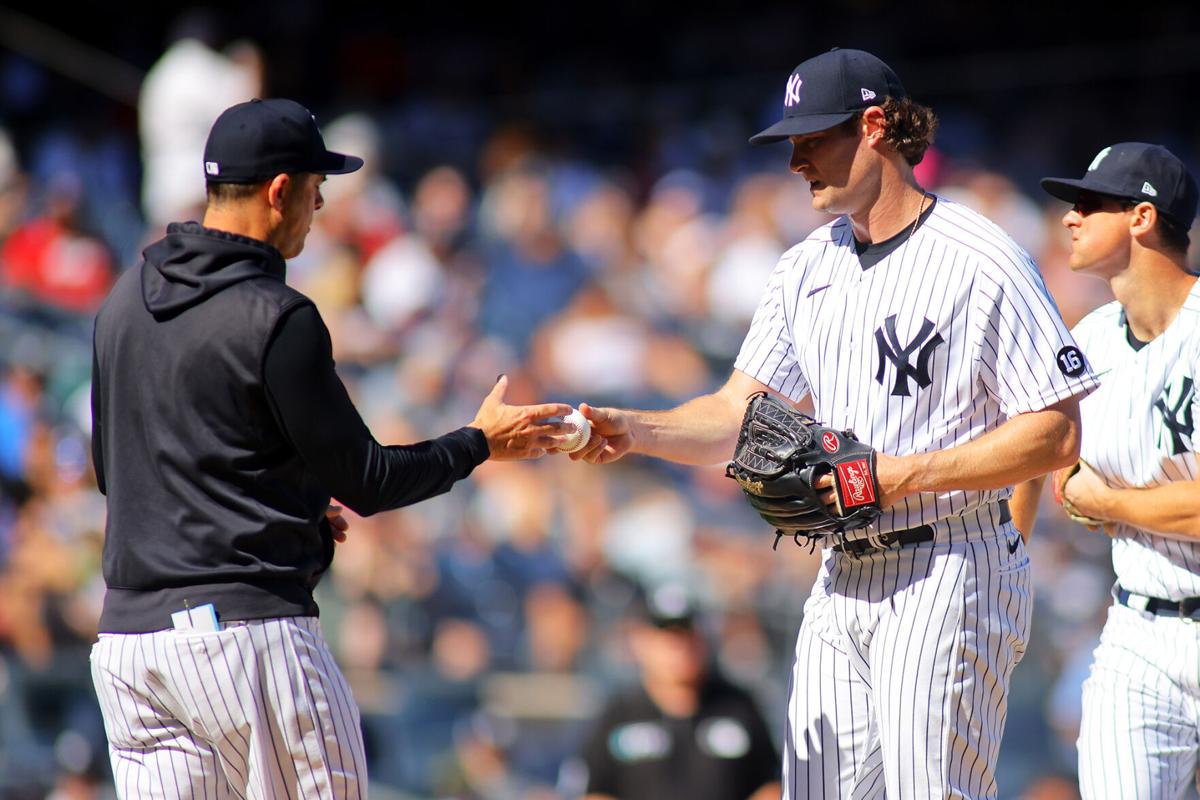 Gerrit Cole of the New York Yankees hands the ball to manager Aaron Boone after being removed in the sixth inning against the Cleveland Indians at Yankee Stadium on September 19, 2021 in New York City.