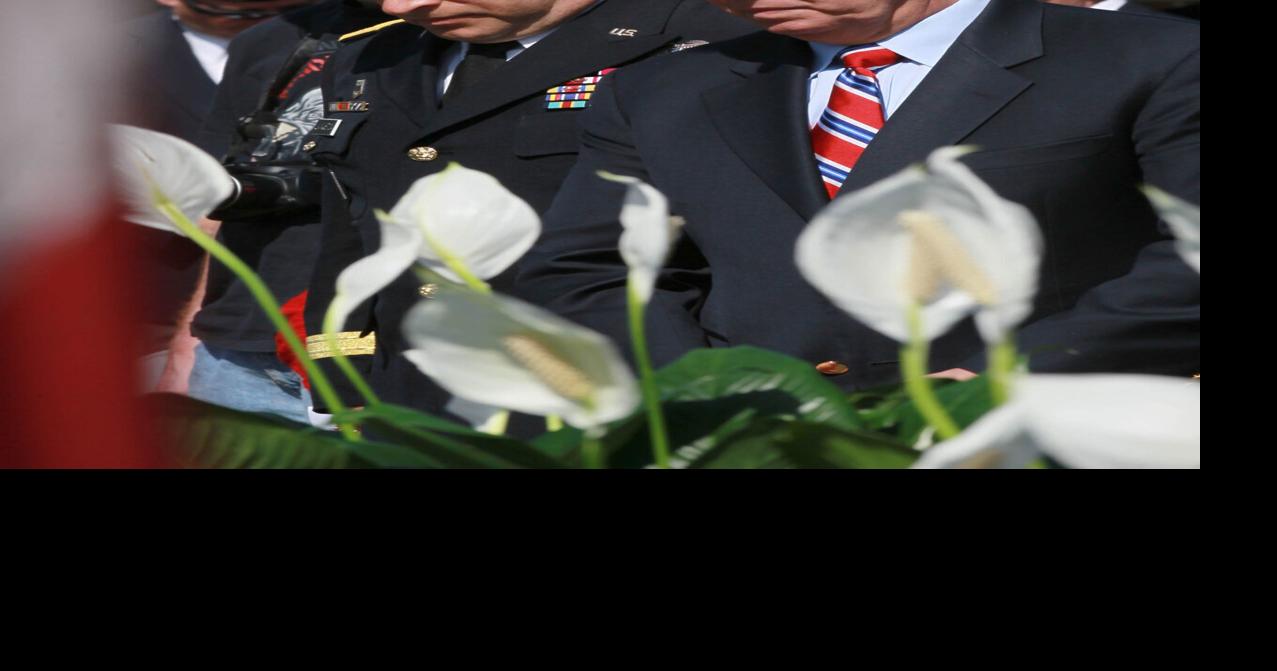 Maj. Gen. Robert Livingston Jr. and U.S. Sen. Lindsey Graham bow their heads, while Pastor Ray Longernecker of Six Mile Baptist